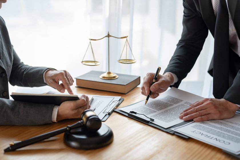 Attorneys reviewing a contract with scales of justice and gavel